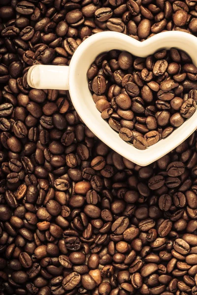 Taza blanca en granos de café —  Fotos de Stock