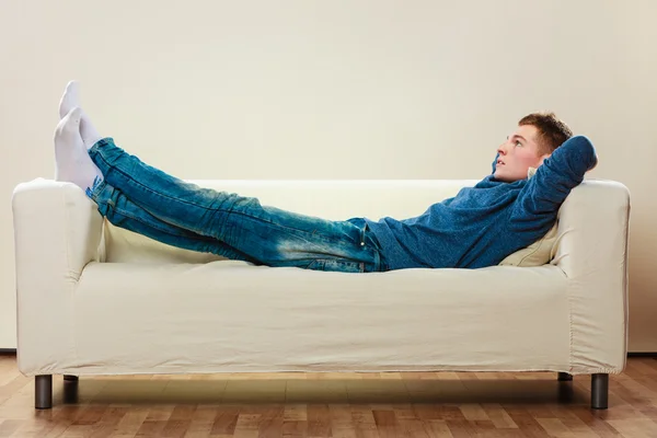 Nachdenklicher Mann entspannt sich auf Couch — Stockfoto
