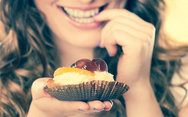 Vrouw eten cake van het fruit — Stockfoto