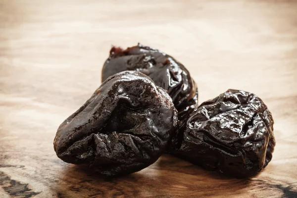 Dried plums on wooden table — Stock Photo, Image