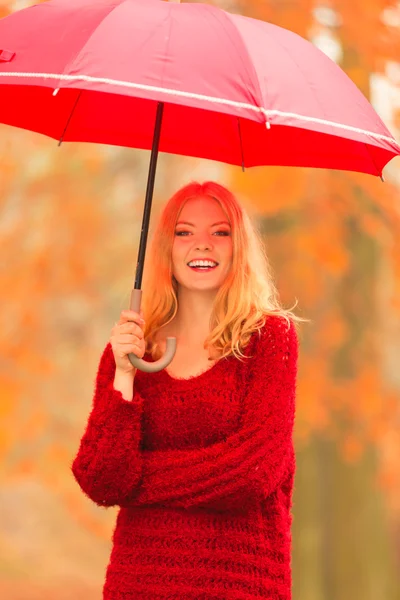 Woman walking with red umbrella in autumn park — Stock Photo, Image