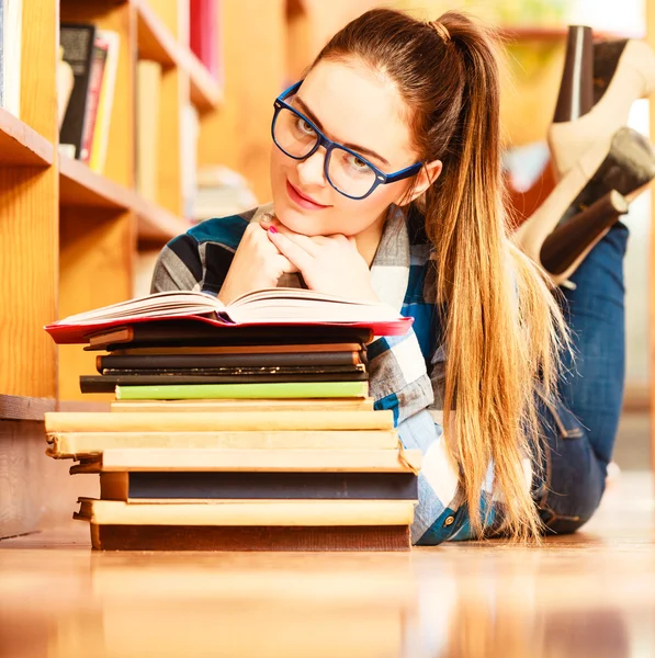 Woman  in blue glasses lying on floor — Stockfoto