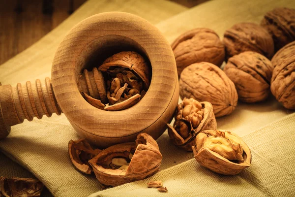 Nueces con cascanueces sobre mesa rústica —  Fotos de Stock