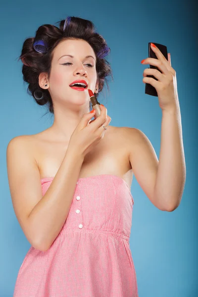 Chica en rulos de pelo aplicando lápiz labial rojo — Foto de Stock