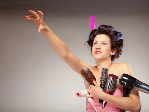 Funny girl styling hair holds many accessories — Stock Photo, Image