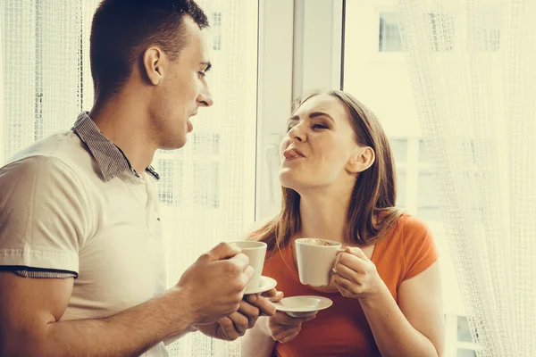Молодая пара пьет чай или кофе дома — стоковое фото