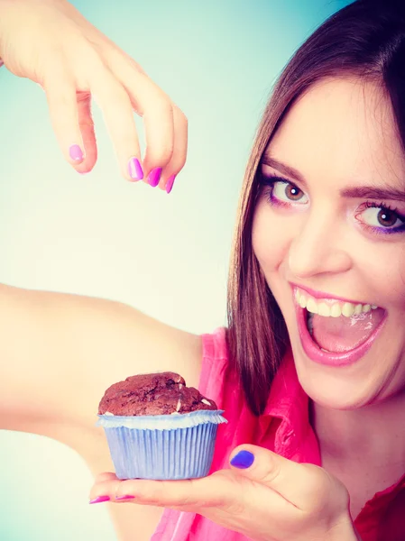 Smiling woman holds chocolate cake in hand — Stock Photo, Image