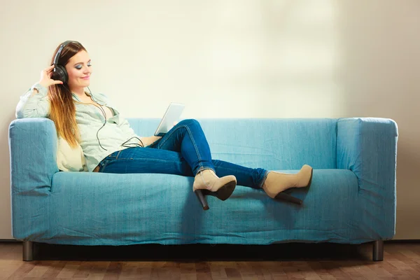 Femme avec casque tablette assis sur le canapé — Photo