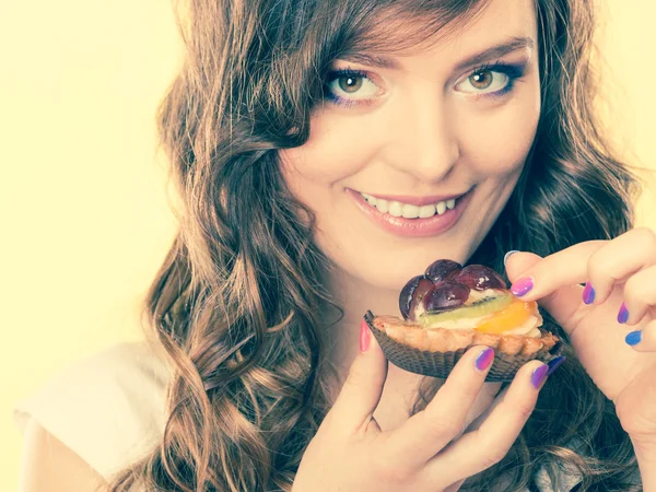 Smiling cute woman holds fruit cake in hand — Stock Photo, Image