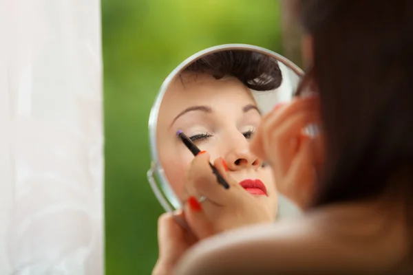 Chica aplicando maquillaje con cepillo —  Fotos de Stock