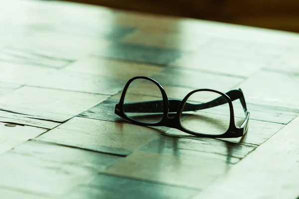 Óculos em uma mesa quadriculada — Fotografia de Stock