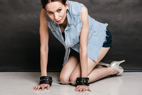 Woman showing leather handcuffs. — Stock Photo, Image