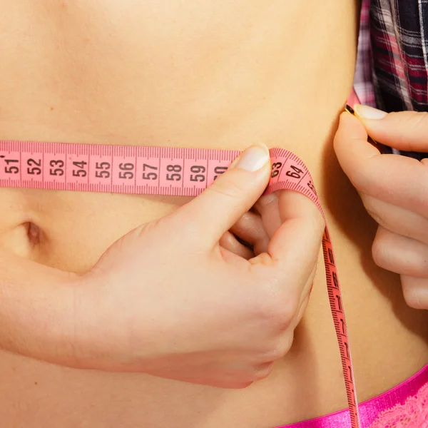 Woman measuring her waistline — Stock Photo, Image