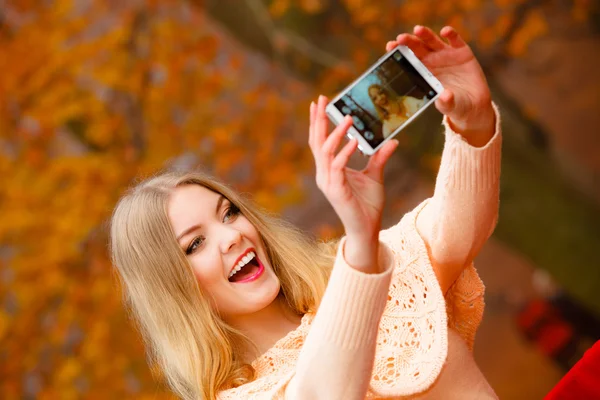 Flicka med själven föreställer med telefon utomhus — Stockfoto