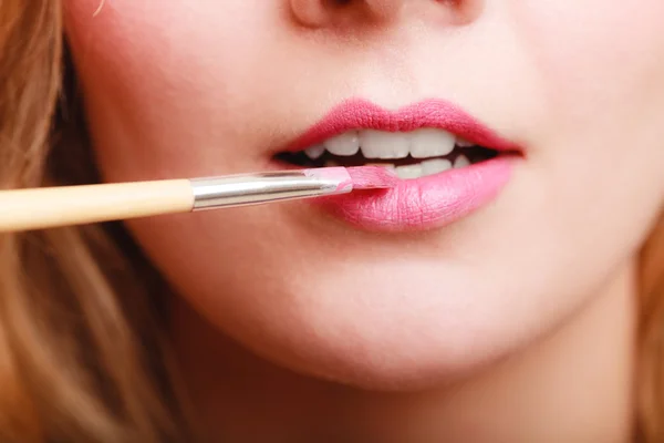 Part of face. Woman applying pink lipstick with brush — Stock Photo, Image