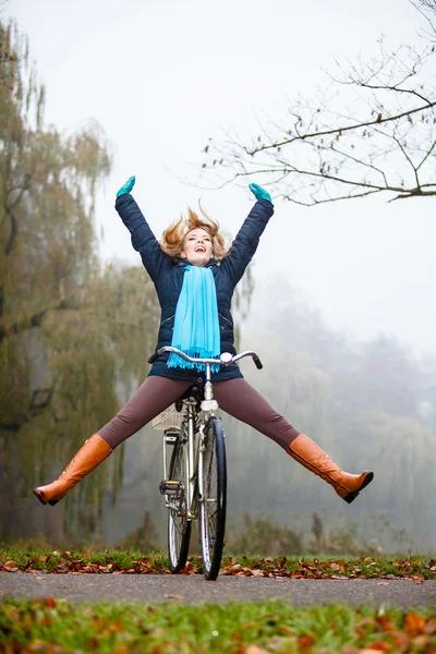 Menina relaxante no parque outonal com bicicleta — Fotografia de Stock
