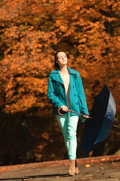 Ragazza che cammina con ombrello blu nel parco autunnale — Foto Stock