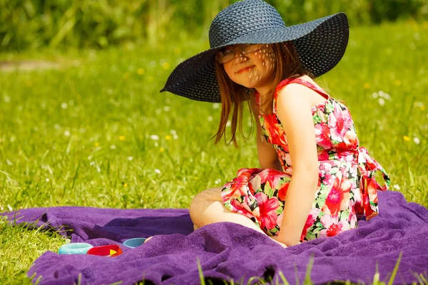 Söt liten flicka i stor hatt låtsas vara lady — Stockfoto