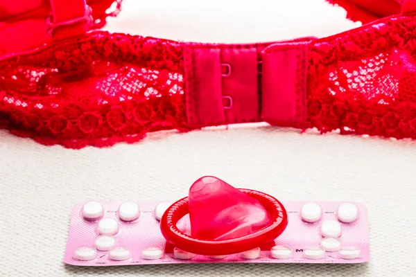 Pills and condom with lace lingerie. — Stock Photo, Image