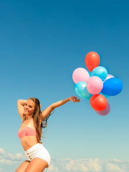 Dziewczyna skacze z kolorowych balonów na plaży — Zdjęcie stockowe