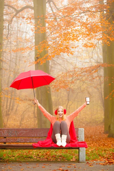 Dívka v podzimním parku těší horký nápoj — Stock fotografie