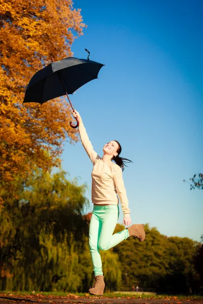 Girl jumping with blue umbrella — Stock Photo, Image