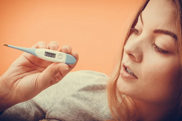 Kvinne som holder digitalt termometer – stockfoto