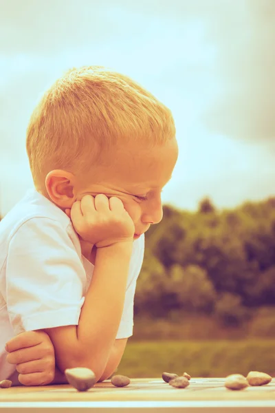 Petit garçon intelligent enfant jouer dames dans le parc — Photo