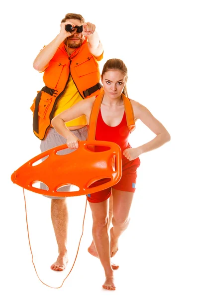 Lifeguards in life vest with rescue buoy running — Stock Photo, Image