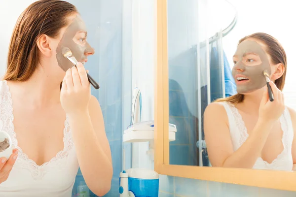 Mulher aplicando máscara facial de lama — Fotografia de Stock