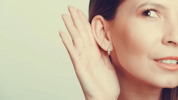 Klatschmädchen belauscht mit der Hand ins Ohr. — Stockfoto