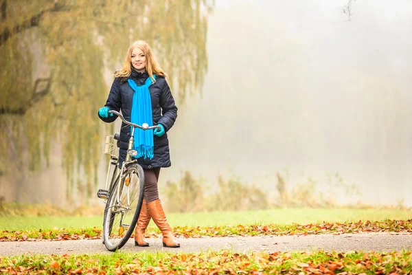 Frau mit Fahrrad im nebligen Park. — Stockfoto