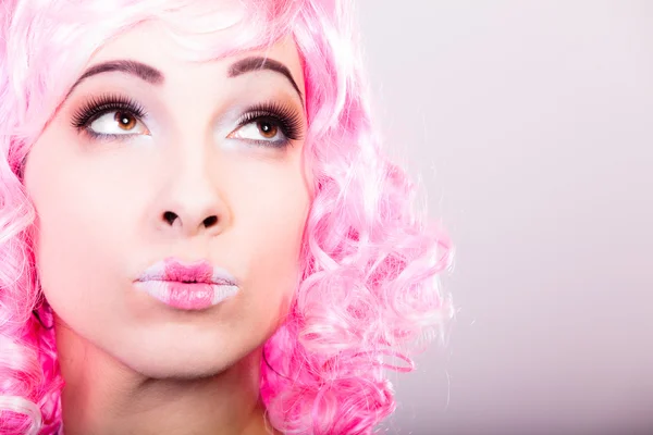 Kvinna i rosa peruk tittar upp — Stockfoto
