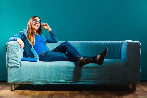 Женщина сидит на диване — стоковое фото