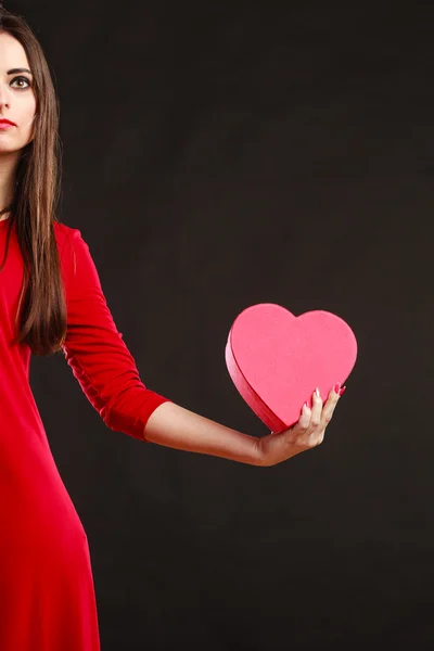 Mujer en vestido rojo sosteniendo caja del corazón. — Foto de Stock