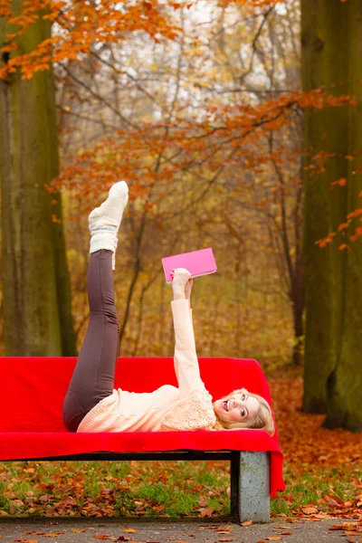 Girl relaxing in autumn park reading book — Stock Photo, Image