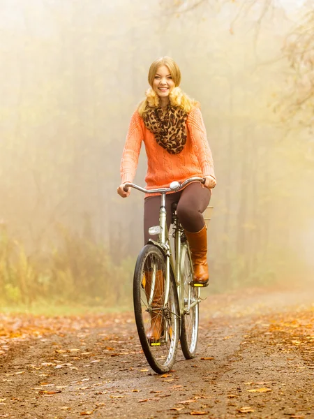 Happy active woman riding bike in autumn park. — Stock Photo, Image