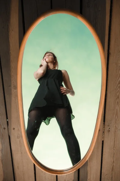 Woman looking  at the reflection in the mirror — Stok fotoğraf