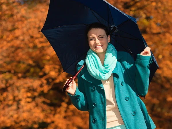 Девушка гуляет с голубым зонтиком в осеннем парке — стоковое фото