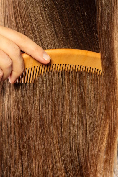 Hand holding wooden comb — Stock Photo, Image