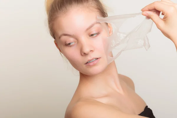 Mujer quitando la máscara de la piel facial — Foto de Stock