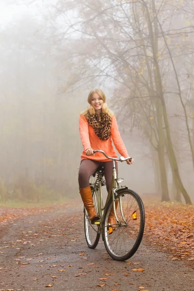 Kobieta jazdy konnej rower w parku jesień. — Zdjęcie stockowe