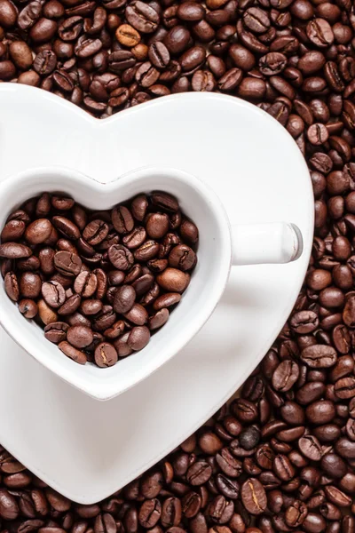 Copo e pires no fundo de grãos de café — Fotografia de Stock