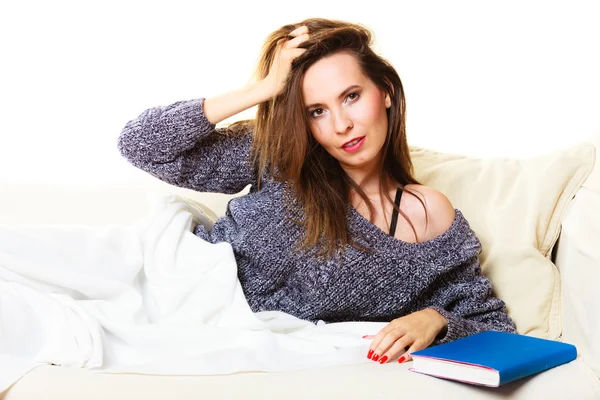 Girl lying on couch with book relaxed — Stock fotografie