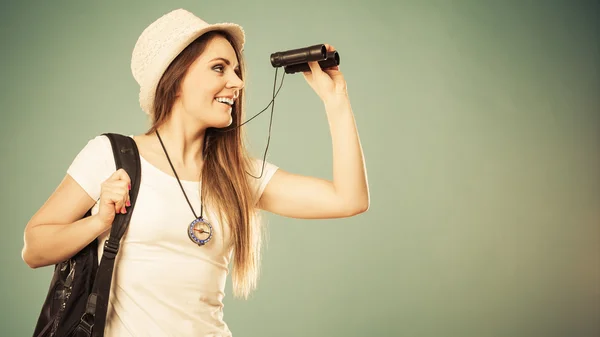 Tourist woman looking through binoculars