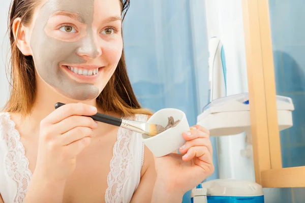 Woman applying mud facial mask — Stock Photo, Image