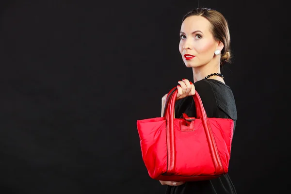 Lady in black dress holding red handbag — Stockfoto