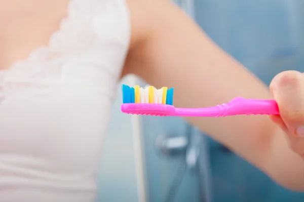 Mão segurando escova de dentes rosa — Fotografia de Stock