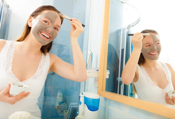 Mujer aplicando mascarilla de barro facial — Foto de Stock