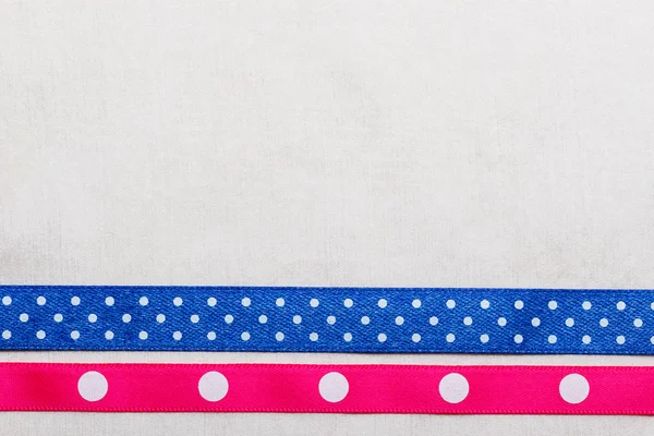 Tečkovaná modrá růžová stuha rám na bílý ubrus — Stock fotografie